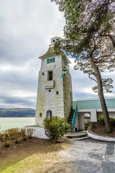Baharda Galler 'in renkli Portmeirion köyünün yanındaki Dwyryd Nehri kıyısındaki bir kuleye doğru bir manzara.