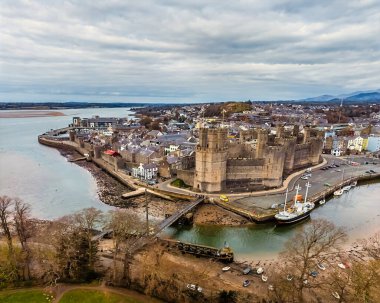 İlkbaharda Galler 'in Caernarfon kasabası ve kalesine doğru uzanan bir hava manzarası.