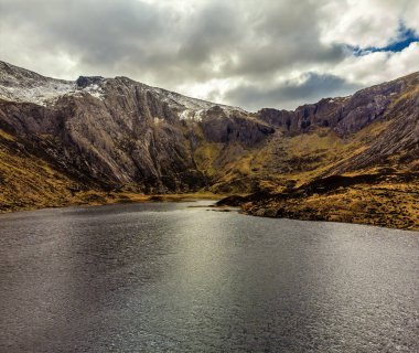 İlkbaharda Galler, Snowdonia 'daki Corrie arka duvarına doğru Idwal Gölü' nün üzerinde bir hava manzarası.