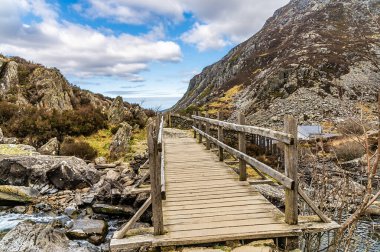 Bahar zamanı Galler 'in Beddgelert kentindeki Snowdonia eteklerinde bulunan Idwal Gölü' ne giden yola bakan bir köprü manzarası.
