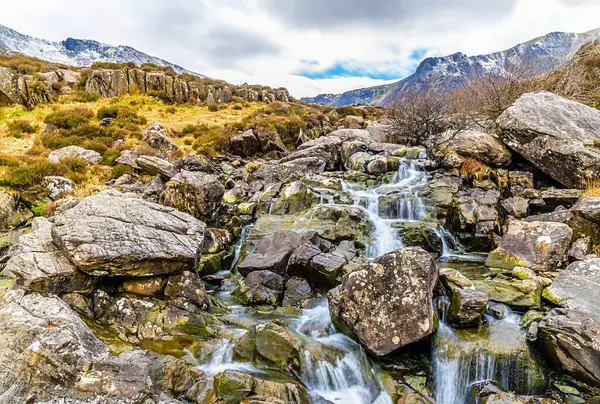İlkbaharda Galler 'in Beddgelert kentindeki Snowdonia eteklerindeki Idwal Gölü' ne giden şelalenin uzun bir görüntüsü.