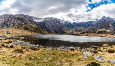 İlkbaharda Galler, Snowdonia 'daki Idwal Gölü' nün karşısındaki dağlara bakan bir manzara.