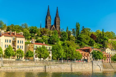 Vltava Nehri 'nden doğu kıyısına doğru bir manzara. Baharda Prag' da Aziz Peter ve Paul Bazilikası 'nın arka planı var.