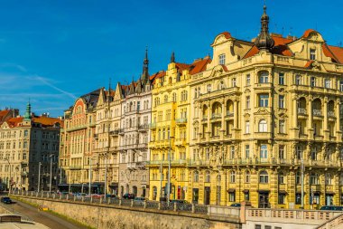İlkbaharda Prag 'daki Lejyon Köprüsü' nden Vltava Nehri 'nin doğu kıyısındaki süslü binanın aşağısında bir manzara.