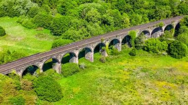 New Mills, Derbyshire, İngiltere 'de yaz mevsiminde Sett Nehri üzerindeki viyadük dönüşümlü hava görüntüsü.