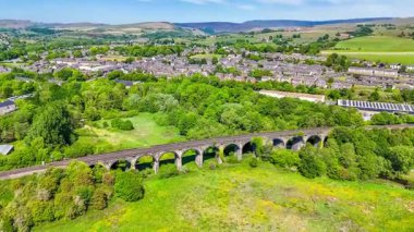 Derbyshire, İngiltere 'nin New Mills kasabasındaki Sett Nehri üzerindeki viyadük manzarası yaz mevsiminde yükseliyor.