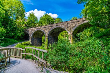 Bu üçlüye giden yolda New Mills 'de Goyt Nehri üzerinde bir köprü vardı. Yazın İngiltere' de High Peak 'te.