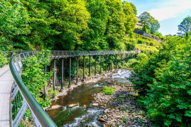 Yazın İngiltere 'de High Peak, New Mills' deki Torrs Riverside Parkı 'nda kullanılmayan bir değirmenin yanında yürüyüş yolu boyunca bir manzara.