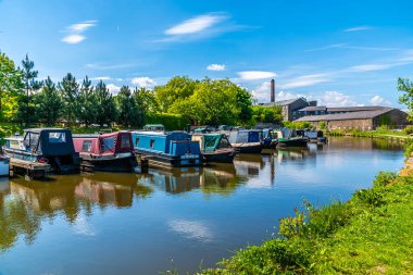 Tepe Ormanı Kanalı 'nın yukarısında New Mills' de demirli bir kanal mavnasını geçince, İngiltere 'de yaz mevsiminde High Peak