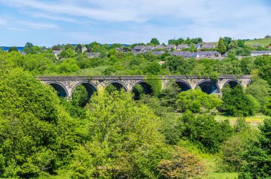 İngiltere 'nin en yüksek tepesindeki New Mills kasabasındaki Midland Demiryolu viyadük' üne doğru ağaçların arasından bir manzara