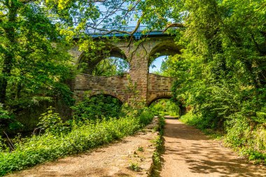 Goyt Nehri boyunca İngiltere 'de yaz aylarında New Mills, High Peak kasabasının yanındaki iki katlı viyadük yoluna doğru bir manzara.