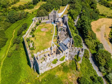 Manorbier, Güney Galler 'deki deniz kıyısındaki tatil beldesinde eski Norman şatosunun üstünde bir hava manzarası var.