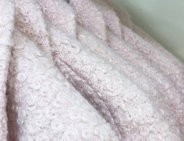 Satılık askılarda asılı açık pembe yün paltolar. Metin alanını kapat