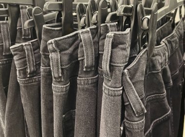 Askıda asılı bir sürü kot pantolon. Dolapta asılı pantolon pantolonu. Alım, satım, alışveriş ve kot pantolon moda konsepti .