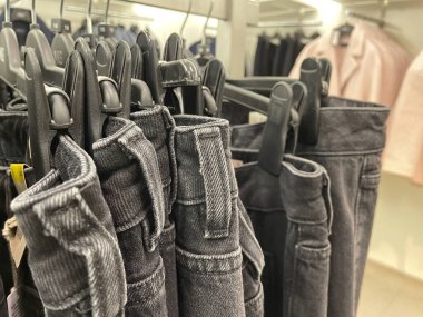 Askıda asılı bir sürü kot pantolon. Dolapta asılı pantolon pantolonu. Alım, satım, alışveriş ve kot pantolon moda konsepti .