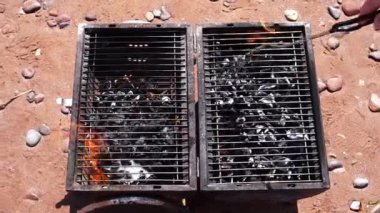 Kumsalda küçük ve eski bir barbekü ızgarası.