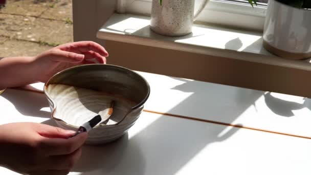Hände Die Eine Zerbrochene Porzellanschale Mit Klebstoff Auf Einem Weißen — Stockvideo