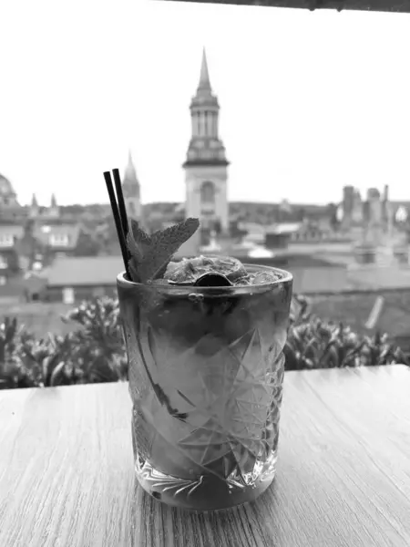 stock image Two refreshing cocktails sit on a table in Oxford, overlooking the historic city skyline with iconic buildings in the background.