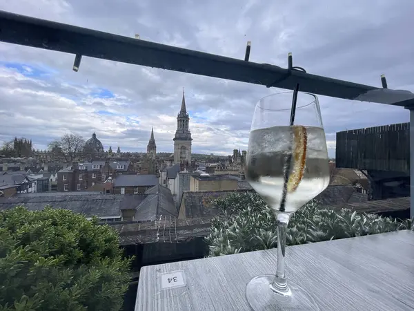 stock image one cocktail sit on a table in Oxford, overlooking the historic city skyline with iconic buildings in the background.