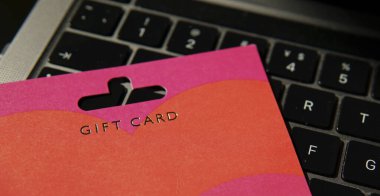 İnternetten alışveriş ve dijital hediye fikirlerini sembolize eden canlı bir hediye kartı. E-ticaret temaları ve hediye ile ilgili promosyonlar için ideal.