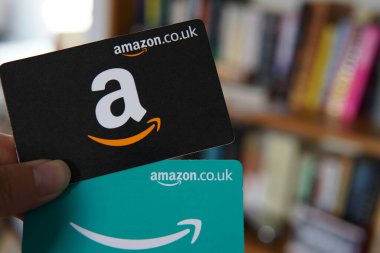 iki Amazon hediye kartı, bir siyah ve bir mavi, kolay online alışveriş ve hediye olanaklarını sembolize ediyor..