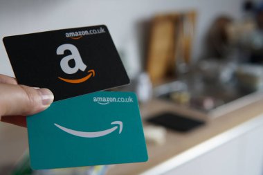 Mutfak geçmişi olan iki Amazon hediye kartı, online alışveriş ve hediye için mükemmel. Doğum günleri, tatiller ve özel günler için popüler bir seçim..