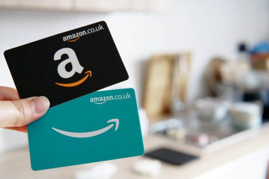 Mutfak geçmişi olan iki Amazon hediye kartı, online alışveriş ve hediye için mükemmel. Doğum günleri, tatiller ve özel günler için popüler bir seçim..