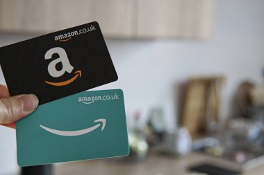 Mutfak geçmişi olan iki Amazon hediye kartı, online alışveriş ve hediye için mükemmel. Doğum günleri, tatiller ve özel günler için popüler bir seçim..