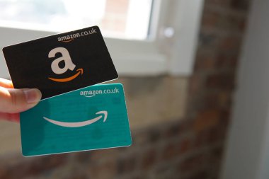 iki Amazon hediye kartı, bir siyah ve bir mavi, kolay online alışveriş ve hediye olanaklarını sembolize ediyor..