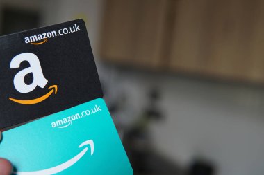 iki Amazon hediye kartı, bir siyah ve bir mavi, kolay online alışveriş ve hediye olanaklarını sembolize ediyor..