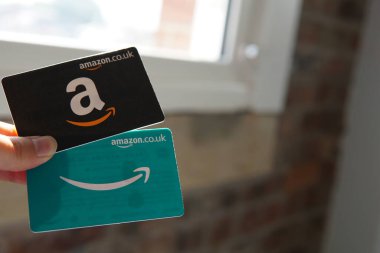 iki Amazon hediye kartı, bir siyah ve bir mavi, kolay online alışveriş ve hediye olanaklarını sembolize ediyor..