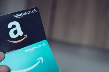 iki Amazon hediye kartı, bir siyah ve bir mavi, kolay online alışveriş ve hediye olanaklarını sembolize ediyor..