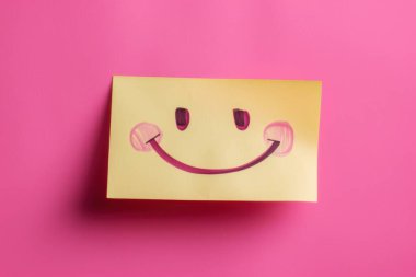 Pembe arka planda sarı gülümseyen yüz çıkartması olan pozitif tutum konsepti