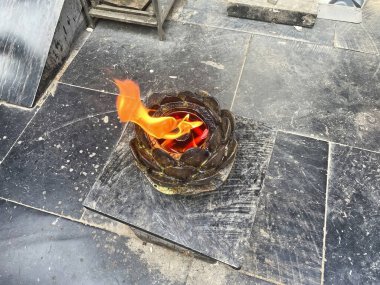 Burning incense sticks in Yonghe temple, hand with incense sticks, pilgrim lighting up his sticks from the fire, pleasant scents is one of the sensory offerings. clipart