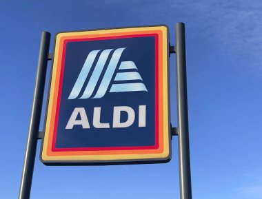 Manchester, İngiltere, 4 Ekim 2024. ALDI mağazasının beyaz bulutlu mavi gökyüzüne karşı ticari işareti. ALDI, iki Alman indirimli süpermarket zincirinin ortak markasıdır..