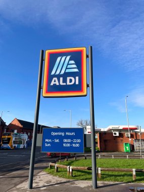Manchester, İngiltere, 4 Ekim 2024. ALDI mağazasının beyaz bulutlu mavi gökyüzüne karşı ticari işareti. ALDI, iki Alman indirimli süpermarket zincirinin ortak markasıdır..