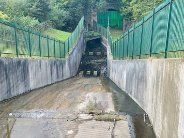 Manchester, İngiltere, 4 Ekim 2024. Gorton 'un alt rezervuarından dökülen su sızıntısı terk edilmiş bir demiryolu tüneli ile birlikte İngiltere' deki Debdale Park Manchester 'ı kontrol ediyor.