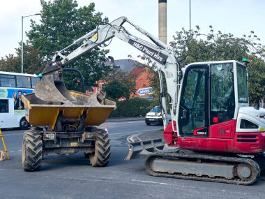 Yeşil güvenlik bariyerleri ve araçlarıyla çevrili yol kazıları, inşaat işleri ve kentsel bakım, sokak güvenliği ve altyapı yönetiminin sağlanması.