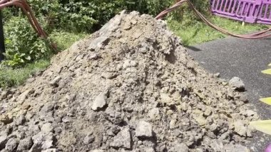 Toprak katmanlarını, kırmızı yeraltı kablolarını ve çevresindeki toprak çalışmalarını gösteren bir inşaat alanı. kazı projeleri, veya kamu hizmetleri kurulumları ve onarım.