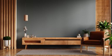 Deri koltuğa asgari düzeyde monte edilmiş bir dolap televizyonu, koyu yeşil bir duvar.