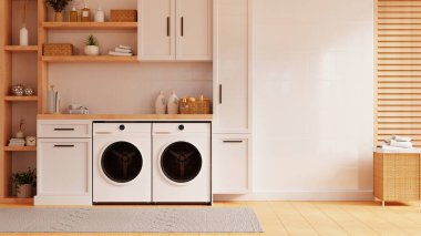 Çamaşır odasında, arka planda beyaz bir duvara dayalı modern çamaşır makinesi.