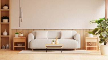 Parlak ve havadar oturma odasında, beyaz yastıklarla bezenmiş, ahşap bir arka fonda dizilmiş, açık gri bir kanepe bulunur.