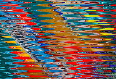 Waves on water in closeup wirh colorful reflections abstract background