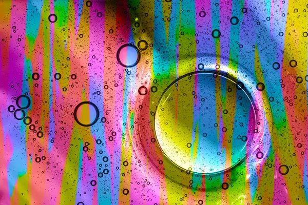 Macro of water drops in oil with a multicolored background