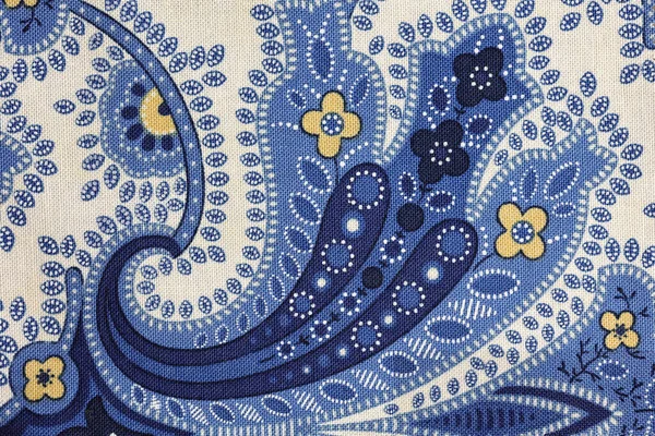 A blue paisley floral pattern in close up