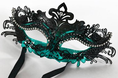 Beyaz bir arka planda mavi ve siyah bir kadın maskesi.