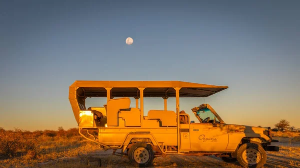 纳米比亚翁古马野生动物保护区日落时带着月亮的Safari车 — 图库照片
