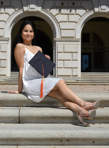 Young attractive Asian American girl with her pug dog preparing for college graduation 