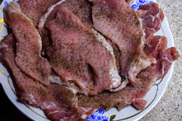 塩とコショウで豚肉はプレート上のチョップを調理するために作られています — ストック写真