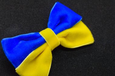 Mavi-sarı kumaştan yapılmış bir yay Ukrayna bayrağı gibi siyah bir arkaplanda